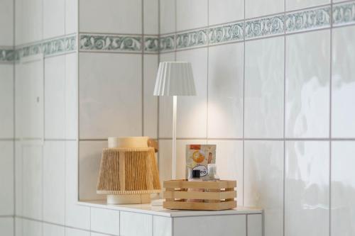 a table with a lamp on a white tiled wall at Ferienwohnung Agnes in Dessau