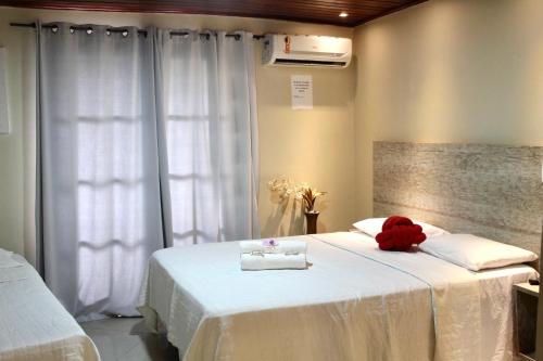 a bedroom with a bed with a teddy bear on it at Atobás in Arraial do Cabo