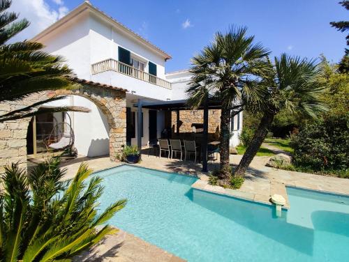 a villa with a swimming pool in front of a house at Villa A CASA DI FICU à 14kms d'Ajaccio et des plages avec Piscine Jacuzzi Pétanque Sans vis à vis in Peri
