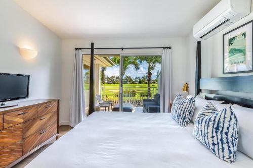 a bedroom with a large bed and a television at Emmalani Court 322 in Princeville