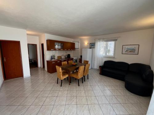 a living room with a black couch and a table at Bronislovas holiday home 1 in Rogoznica