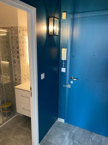 La salle de bains est pourvue d'un lavabo et d'une porte bleue. dans l'établissement L'Astrolabe - Studio - refurbished - seaside, à Cannes
