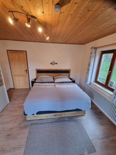a large bed in a room with a wooden ceiling at Apartment Auszeit in Bad Ischl
