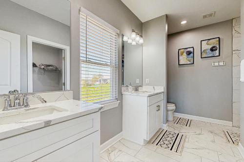 a white bathroom with two sinks and a toilet at Sunset Valley in Kirk O'Cliff