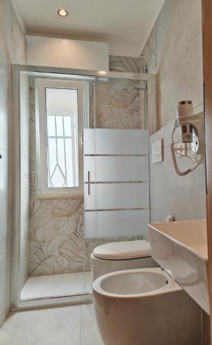 a bathroom with a toilet and a sink and a window at Appartamento estivo PONENTE - Misano Adriatico -RN- in Misano Adriatico
