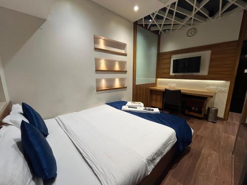 a bedroom with a bed and a desk and a television at Zenith Luxe Suites - Near IIT & Hiranandani, Powai in Mumbai