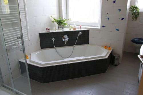 een badkamer met een bad en een douche bij Jürgen Ferienwohnung in Wernigerode