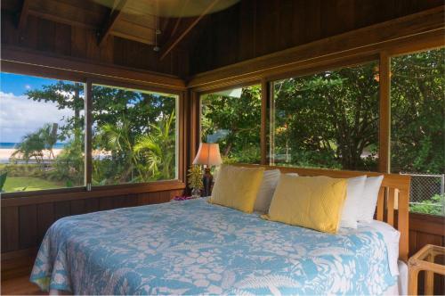 a bedroom with a bed with a view of the ocean at Wainiha Beach Hale in Wainiha