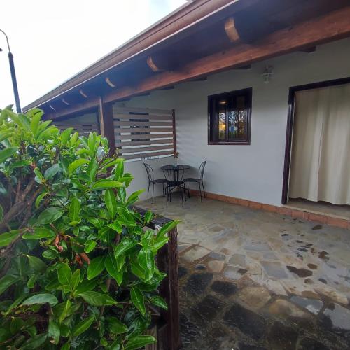 a patio of a house with a table and chairs at Arco delle Rose Rooms in Agropoli