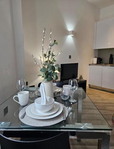a dining table with plates and a vase of flowers at Urban Living I Free Parking in Slough