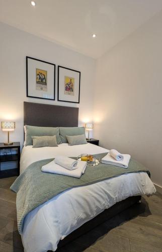 a bedroom with a large bed with towels on it at Urban Living I Free Parking in Slough
