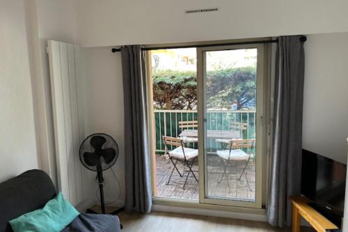 - un salon avec une porte s'ouvrant sur une terrasse dans l'établissement Apartment 20 m from the sea - Cavalaire-sur-Mer, à Cavalaire-sur-Mer