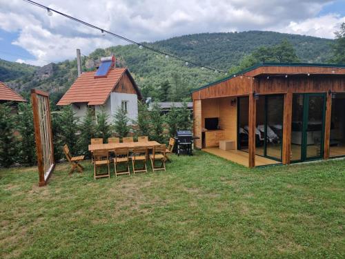 a house with a picnic table and a building at Noor House 1 in Şuncuiuş