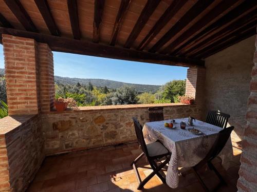a table and chairs on a patio with a view at Agriturismo e Glamping Serraiola Alta in Frassine