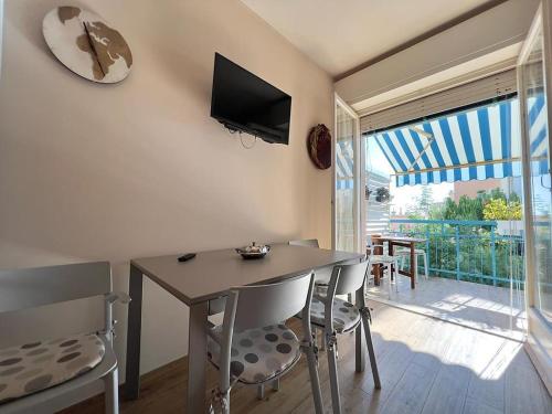 a dining room with a table and chairs and a balcony at Sogno di Riviera in Sanremo