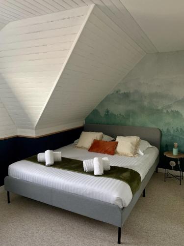 une chambre avec un grand lit dans un grenier dans l'établissement Le cottage du Lenn, à Louannec