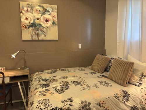 a bedroom with a bed and a desk and a painting at Bayview Bed and Breakfast in Mill Bay