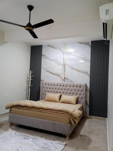 a bed in a room with a ceiling fan at Al Khashabah Apartment شقة في طريق إزكي - سناو in Mukhtari‘