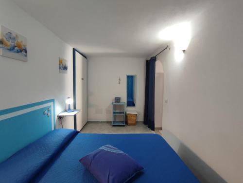 a bedroom with a blue bed with a purple pillow at Appartamento Meduse in Cala Gonone