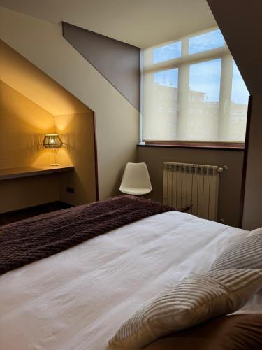 a bedroom with a large bed and a window at Hotel Boutique Villa de Noreña in Noreña