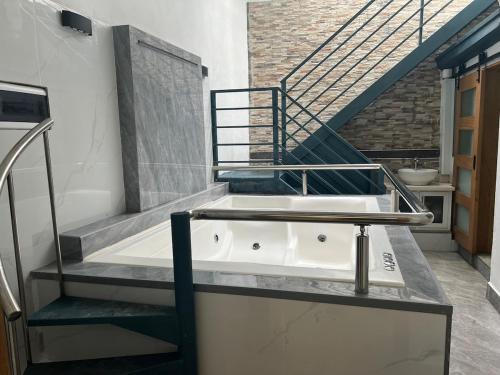 a bath tub in a bathroom with a staircase at Luxury 2 Bed Room with Jacuzzi Patio Malecon in Santo Domingo