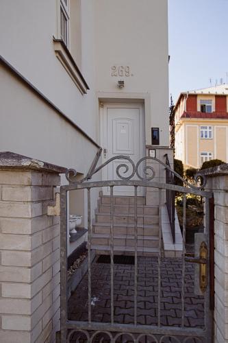 a stairway leading to a white building with a gate at Villa Patriot Apartmány in Mariánské Lázně