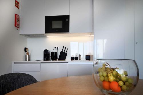 a bowl of fruit sitting on a table in a kitchen at Feel So Good Apartment with Sea View & Jacuzzi in Sesimbra