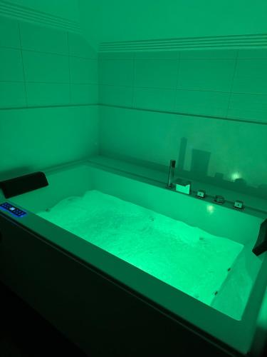 a bathroom with a tub with green lighting at Hotel Boutique Villa de Noreña in Noreña