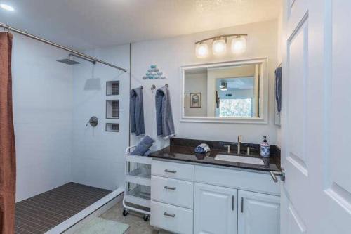 a bathroom with a sink and a mirror and a shower at Emmalani Court 423 in Princeville