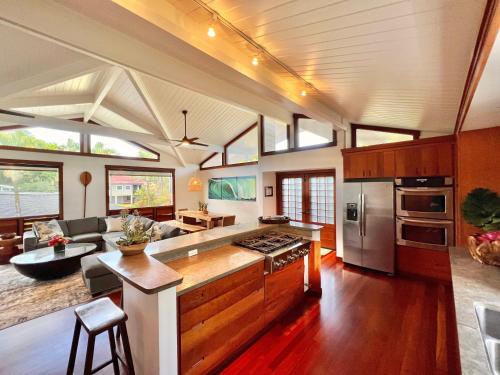 a kitchen and living room with a stove top oven at Hale Aku in Hanalei