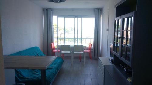 un salon avec un canapé et une table avec des chaises dans l'établissement Studio Sète, à Sète