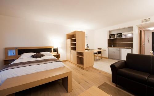 a bedroom with a bed and a desk and a couch at Les Logis D'Espale in Sausheim