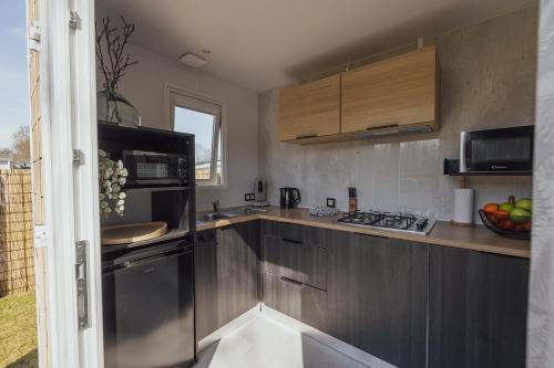 a kitchen with stainless steel cabinets and a sink at De Frije Fûgel - Een luxe chalet op De Friese Wadden in Tzummarum