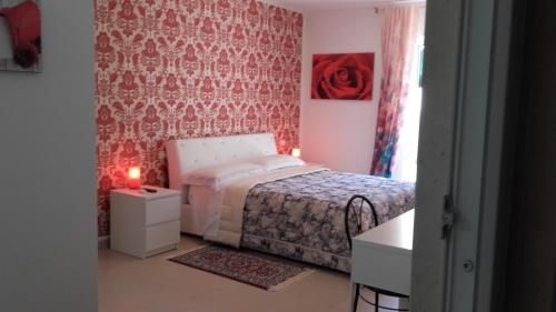 カザマッシマにあるLe Tre Rose Bed & Breakfastの赤い壁のベッドルーム1室(ベッド1台付)