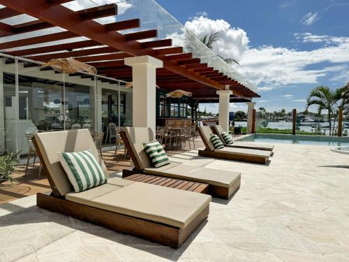 a patio with lounge chairs and a pool at Hotel Premium Recanto da Passagem in Cabo Frio