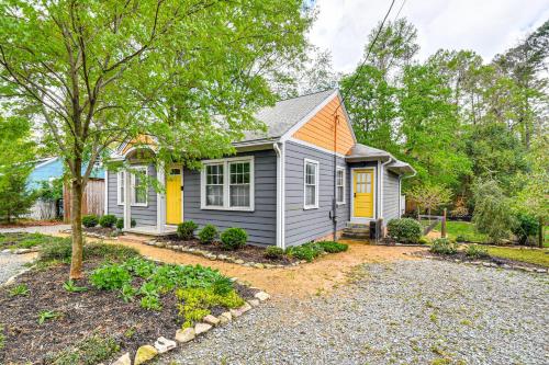 a small house with a yellow door in a yard at Renovated Carrboro House with Deck and Fire Pit! in Carrboro