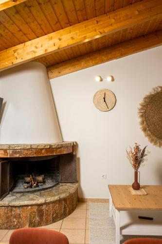 a living room with a fireplace and a wooden ceiling at Rokani Sofita I at Kalavrita Center in Kalavrita
