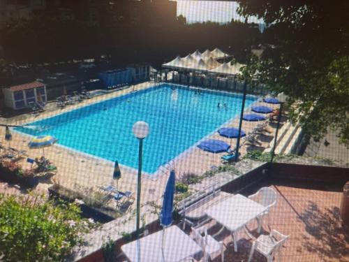 a swimming pool with umbrellas and tables and chairs at Eremia in Giardini Naxos
