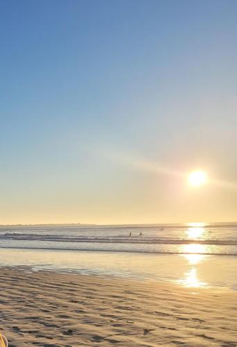 - une plage au soleil se levant au-dessus de l'océan dans l'établissement Les pieds dans l eau, à Penmarcʼh