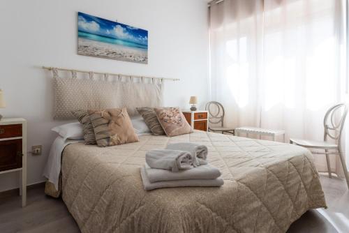 a bedroom with a bed with towels on it at Mondello House Eraclea in Mondello