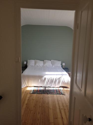 une chambre avec un lit blanc et un parquet dans l'établissement Les pieds dans l eau, à Penmarcʼh