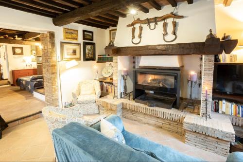 un soggiorno con divano e camino di GiuMa Tuscany Historic Lux Farmhouse near Saturnia Spa a Montemerano