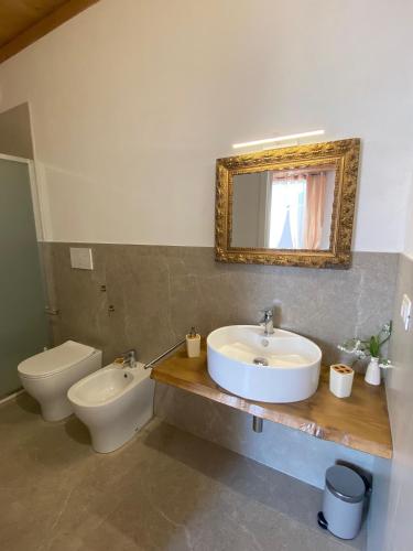a bathroom with a sink and a toilet and a mirror at Seaside - A Due Passi Dal Mare in Fano