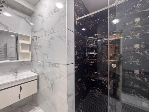 a bathroom with a shower with black and white marble at Samarkand Premium Apartment in Samarkand
