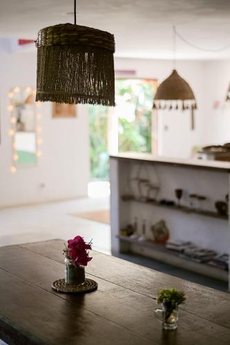 a table with a vase of flowers on top of it at Sambaqui Hostel in Ilhabela