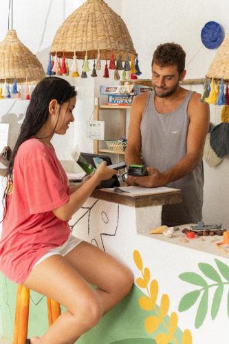 a man and a woman sitting at a counter at Sambaqui Hostel in Ilhabela