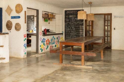 a table in a kitchen with a chalkboard on the wall at Sambaqui Hostel in Ilhabela
