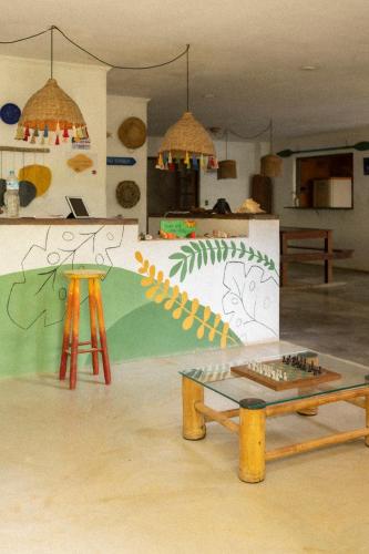 a room with a table and a counter with a wall at Sambaqui Hostel in Ilhabela