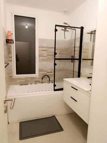 une salle de bain avec une douche, une baignoire et un lavabo dans l'établissement Maison 6-8 personnes à 12km du Puy du Fou, à Chambretaud