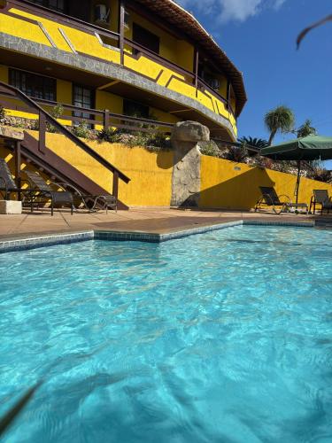 a large swimming pool in front of a building at Atobás in Arraial do Cabo